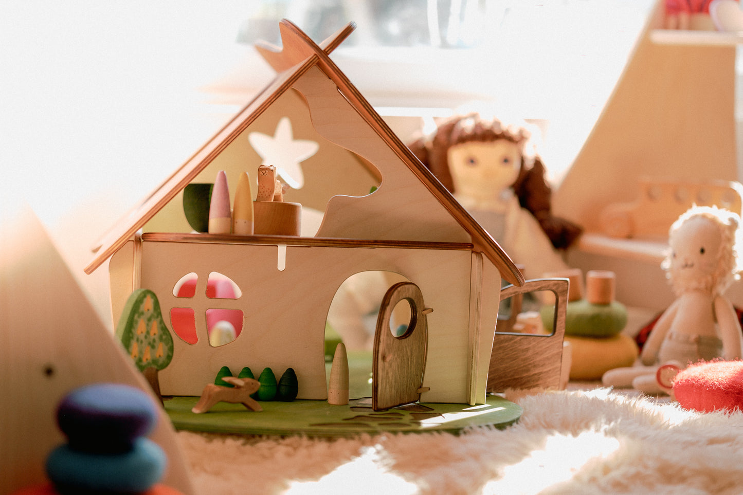 Wooden toy house with decorative elements on a soft surface